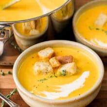 pot full of Butternut Squash Soup with plated bowls and croutons