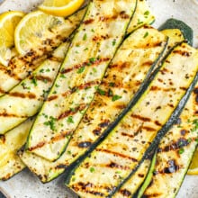 a plate of grilled zucchini with lemon slices
