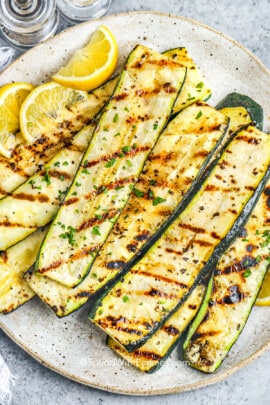 a plate of grilled zucchini with lemon slices