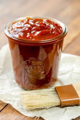 a jar of homemade bbq sauce with a brush