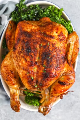 a cooked rotisserie chicken with parsley
