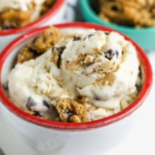 a bowl of homemade cookie dough ice cream with cookie dough in the background