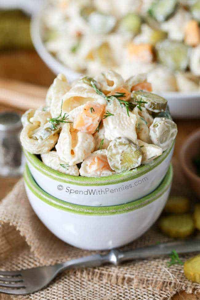 Dill PIckle Pasta Salad in a small bowl with a bigger bowl of it in the background