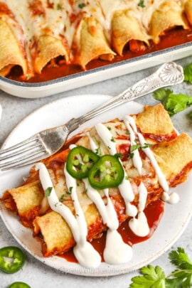plated Easy Chicken Enchiladas and dish full in the back