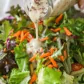 Pouring honey mustard dressing over a salad