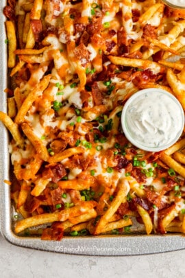 a pan of cooked cheese fries with bacon