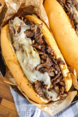 philly cheesesteak topped with cheese in a roll