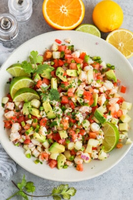 top view of Shrimp Ceviche in a bowl with lemons and limes around it