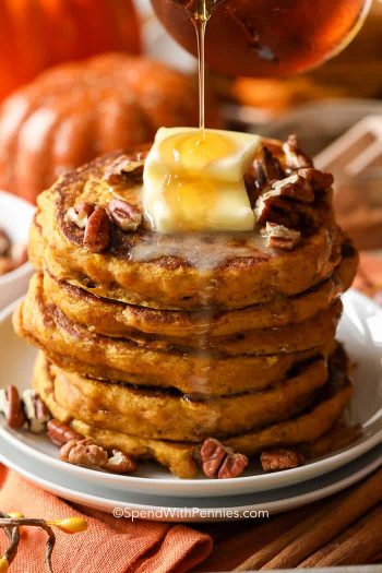 Pouring syrup over a stack of Pumpkin Pancakes