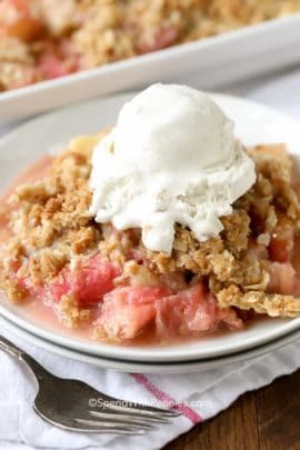 Rhubarb Crisp served on a white plate with ice cream on top