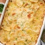 baked scalloped potatoes in dish with herbs