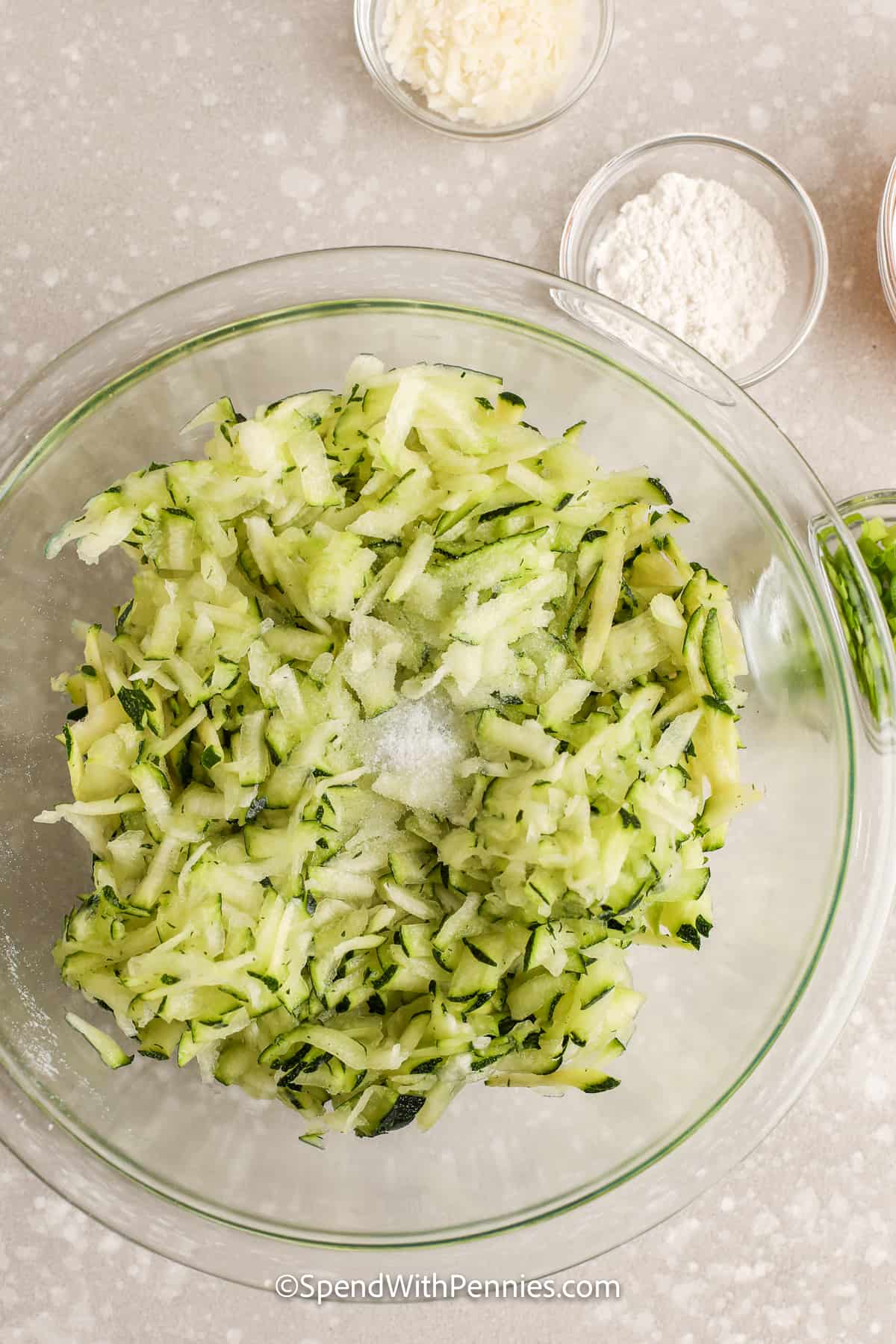 shredded zucchini in a bowl with salt on top