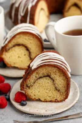 slice of Sour Cream Coffee Cake on plates with a coffee beside it