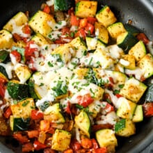 Sauteed zucchini and tomatoes in a pan with cheese
