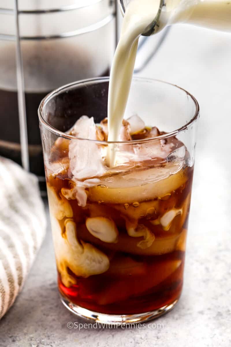 pouring sweet cream into coffee to make Vanilla Sweet Cream Cold Brew